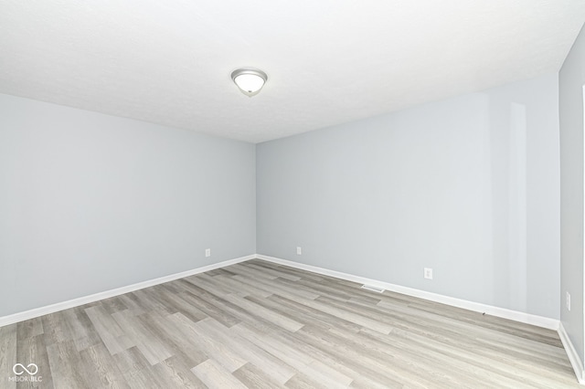 spare room featuring light wood-style flooring and baseboards