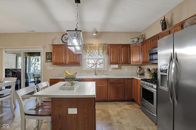 kitchen with light countertops, a breakfast bar area, a sink, and stainless steel appliances