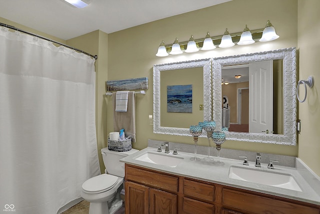full bath featuring tile patterned flooring, double vanity, a sink, and toilet