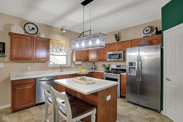 kitchen with a center island, light countertops, brown cabinetry, stainless steel appliances, and a sink