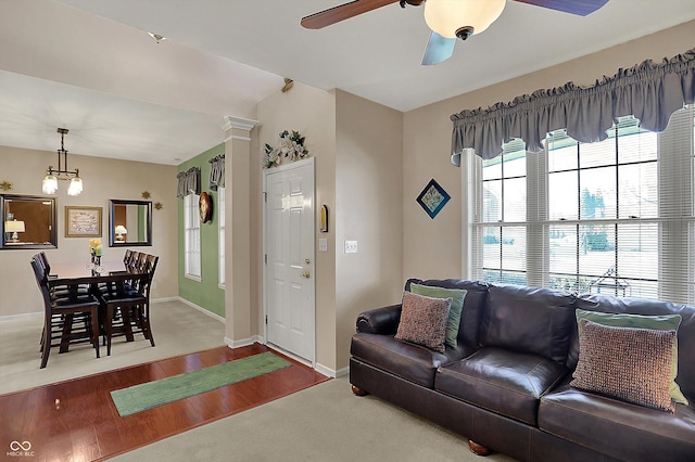 living area featuring wood finished floors, baseboards, and a ceiling fan