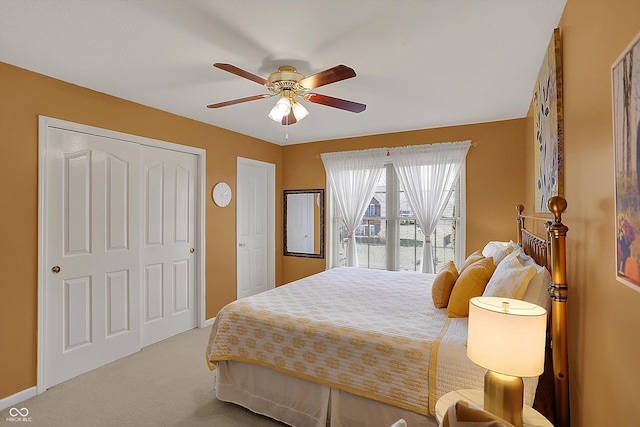 carpeted bedroom featuring ceiling fan, baseboards, and multiple closets