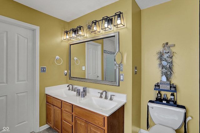 bathroom with double vanity, a sink, and toilet