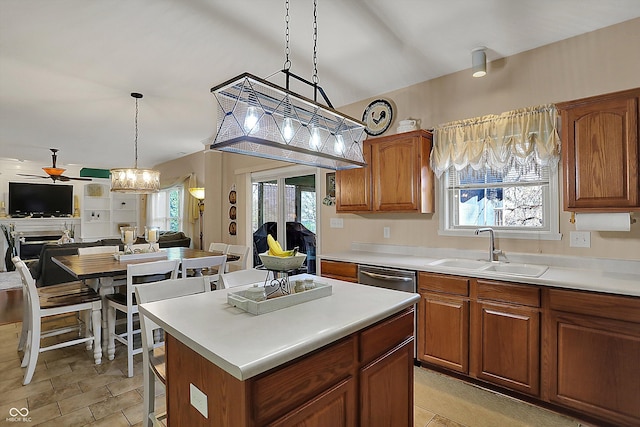 kitchen featuring a sink, open floor plan, light countertops, ceiling fan with notable chandelier, and a kitchen island