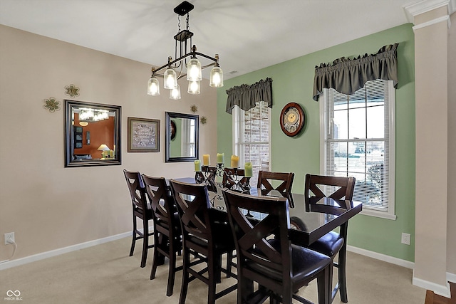 carpeted dining area featuring a chandelier and baseboards