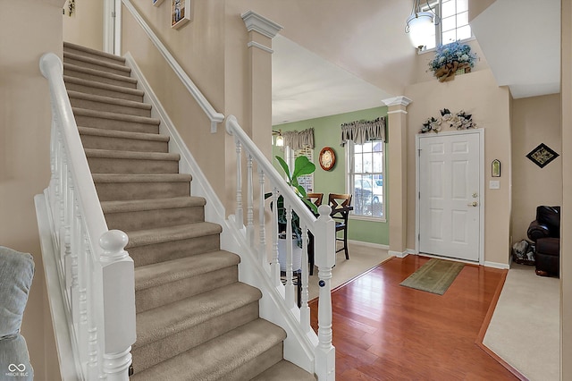 entrance foyer with stairs, ornate columns, baseboards, and wood finished floors
