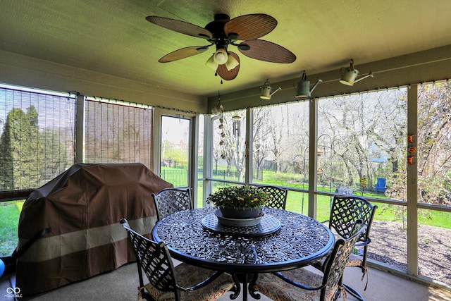 sunroom with a ceiling fan and outdoor dining area