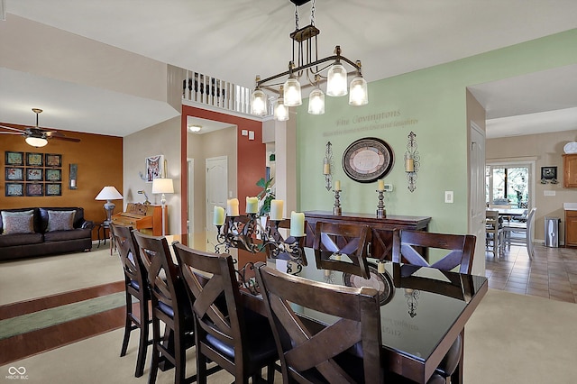 carpeted dining area featuring ceiling fan with notable chandelier and tile patterned flooring