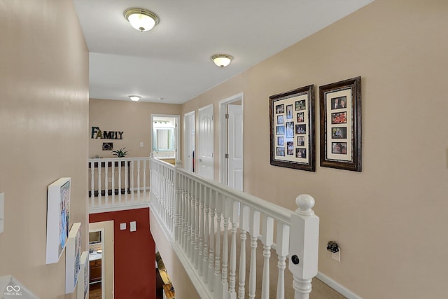 hallway featuring baseboards and an upstairs landing