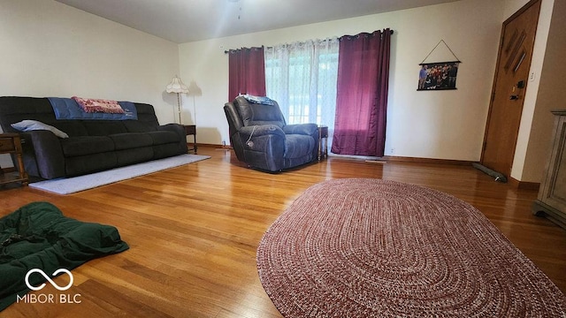 living area featuring baseboards and wood finished floors