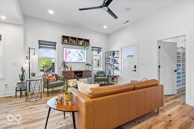 living room featuring a wealth of natural light, a ceiling fan, light wood-style flooring, and visible vents