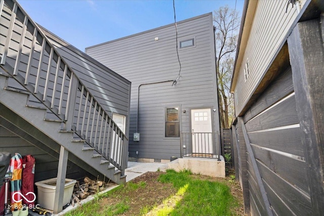 back of property with stairs and crawl space