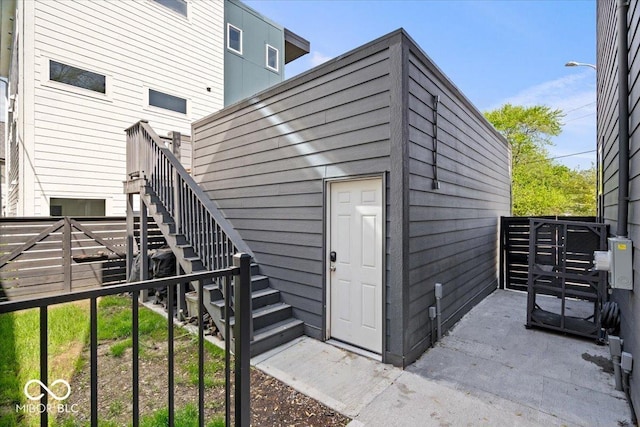 view of outbuilding with stairway and fence