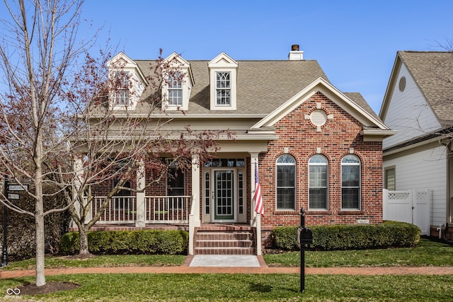 4030 Statesmen Dr, Indianapolis, IN 46250 - view of front of house featuring roof with shingles, a front yard, brick siding, a porch, and a chimney