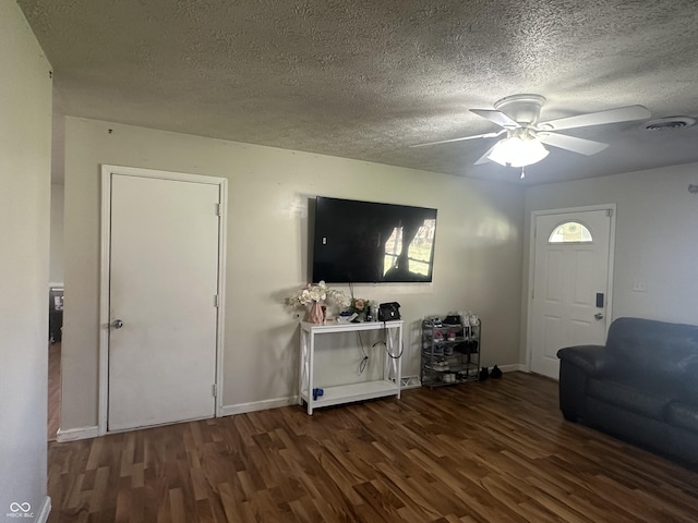 unfurnished living room featuring ceiling fan, baseboards, a textured ceiling, and wood finished floors