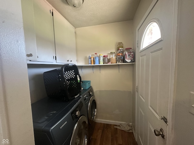 clothes washing area featuring dark wood finished floors, cabinet space, washing machine and dryer, and a textured ceiling
