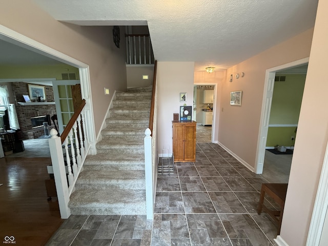 7341 Campfire Run, Indianapolis, IN 46236 - staircase featuring baseboards, a brick fireplace, and a textured ceiling