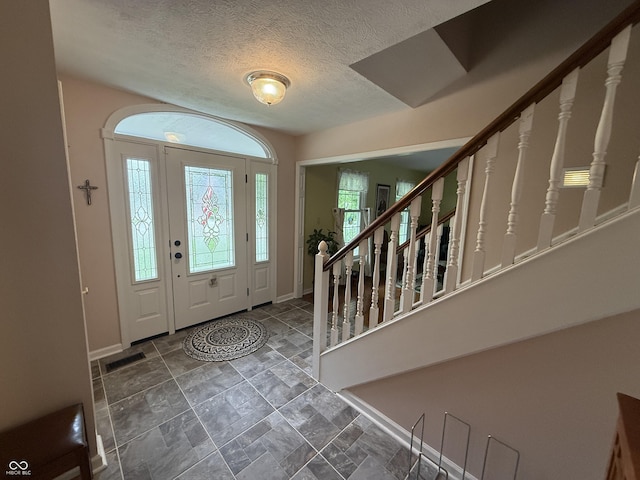 7341 Campfire Run, Indianapolis, IN 46236 - entrance foyer with baseboards, stairs, stone finish floors, and a textured ceiling