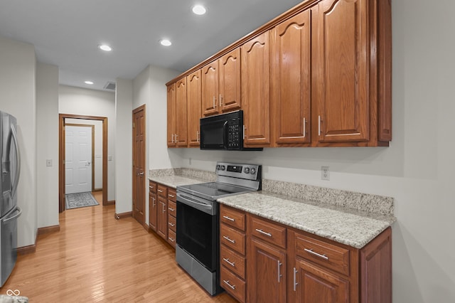 kitchen featuring appliances with stainless steel finishes, brown cabinets, baseboards, light wood-style floors, and recessed lighting