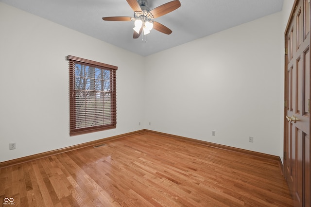 unfurnished room with light wood finished floors, baseboards, visible vents, and a ceiling fan
