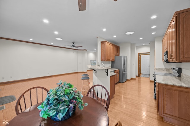 dining area with a ceiling fan, baseboards, light wood-style flooring, and recessed lighting