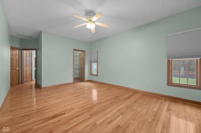 unfurnished bedroom featuring baseboards, light wood-style flooring, and multiple windows