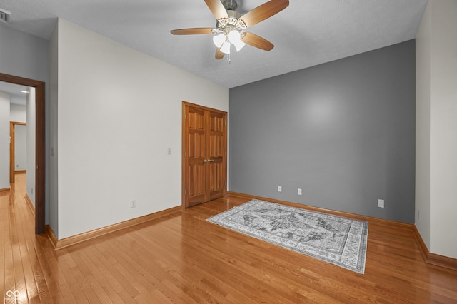 unfurnished room with visible vents, hardwood / wood-style flooring, baseboards, and ceiling fan