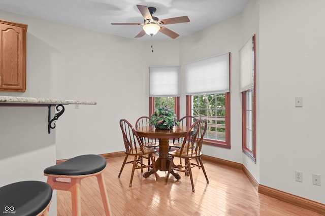 dining area with baseboards, light wood-type flooring, and ceiling fan