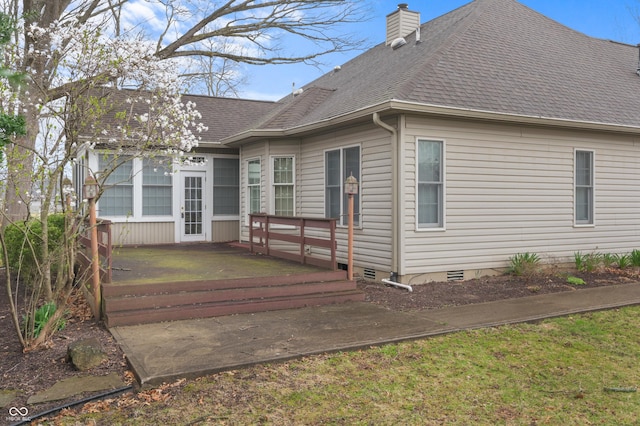 rear view of house featuring a chimney, a wooden deck, crawl space, and roof with shingles