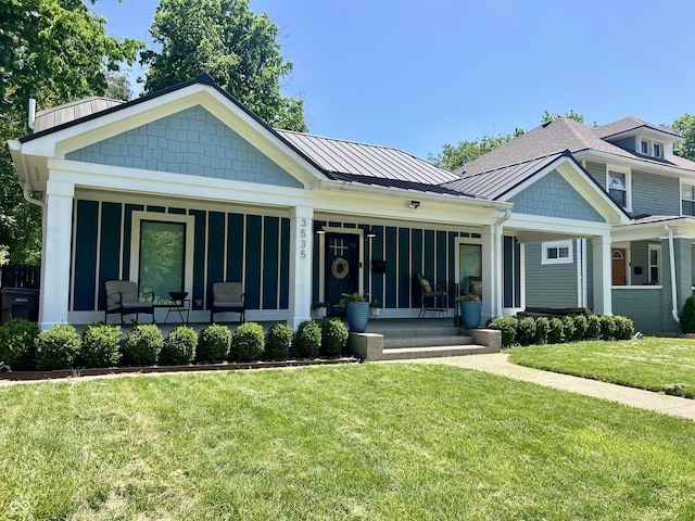 3535 Birchwood Ave, Indianapolis, IN 46205 - view of front of house featuring a standing seam roof, a front lawn, a porch, and metal roof