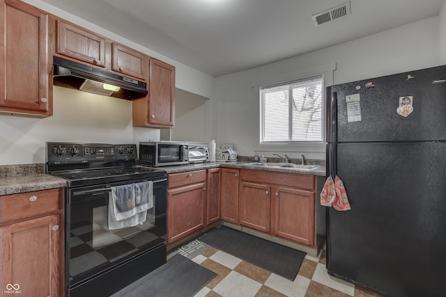 5110 Chelsea Rd, Indianapolis, IN 46241 - kitchen with visible vents, light floors, under cabinet range hood, a sink, and black appliances