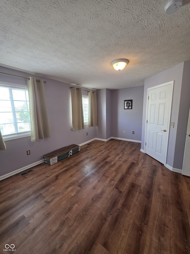 8160 Shores Edge Way, Indianapolis, IN 46237 - unfurnished room featuring dark wood-type flooring, a textured ceiling, baseboards, and a smoke detector