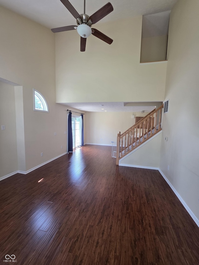 8160 Shores Edge Way, Indianapolis, IN 46237 - unfurnished living room featuring a towering ceiling, ceiling fan, baseboards, wood finished floors, and stairs