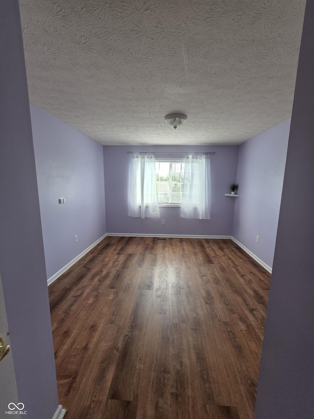 8160 Shores Edge Way, Indianapolis, IN 46237 - unfurnished room with dark wood finished floors, baseboards, and a textured ceiling