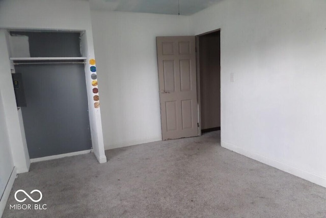 unfurnished bedroom with electric panel, carpet, and baseboards