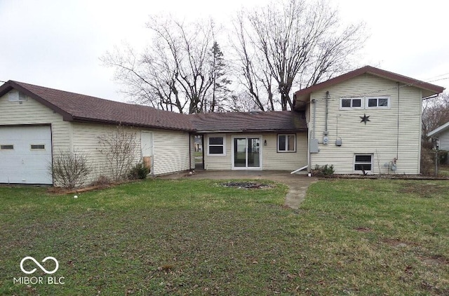 back of property featuring a yard and a garage