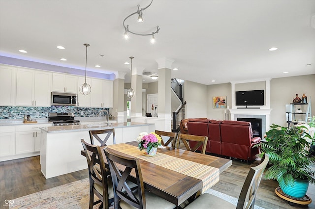 15752 Matthews Ln, Noblesville, IN 46060 - dining room featuring a tiled fireplace, recessed lighting, dark wood-style flooring, and stairs