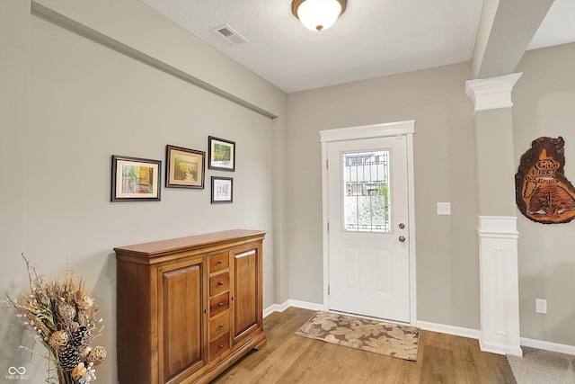 15752 Matthews Ln, Noblesville, IN 46060 - foyer entrance featuring ornate columns, baseboards, light wood finished floors, and visible vents