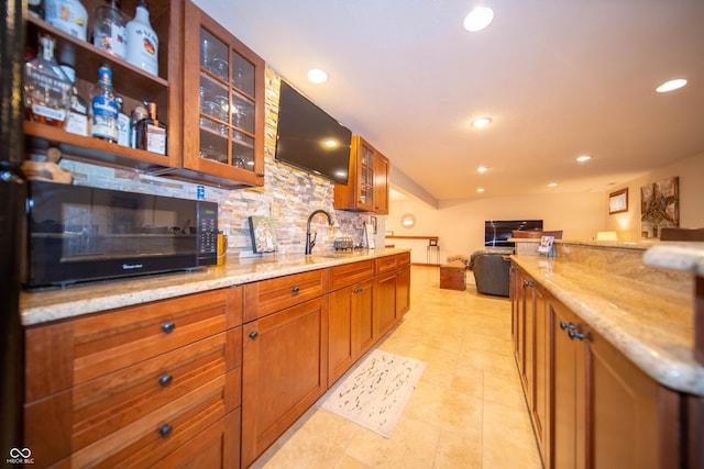 7732 Ashtree Dr, Indianapolis, IN 46259 - kitchen with a sink, black microwave, decorative backsplash, light stone counters, and recessed lighting