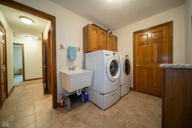 7732 Ashtree Dr, Indianapolis, IN 46259 - laundry area with light tile patterned floors, a sink, separate washer and dryer, cabinet space, and a textured ceiling