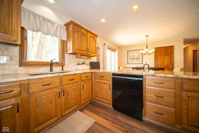 7732 Ashtree Dr, Indianapolis, IN 46259 - kitchen with brown cabinets, a sink, a notable chandelier, light stone countertops, and dishwasher