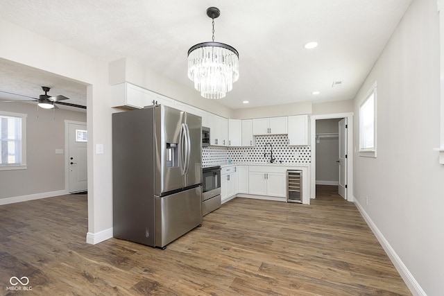 240 E Caven St E, Indianapolis, IN 46225 - kitchen with dark wood finished floors, beverage cooler, white cabinetry, and stainless steel appliances