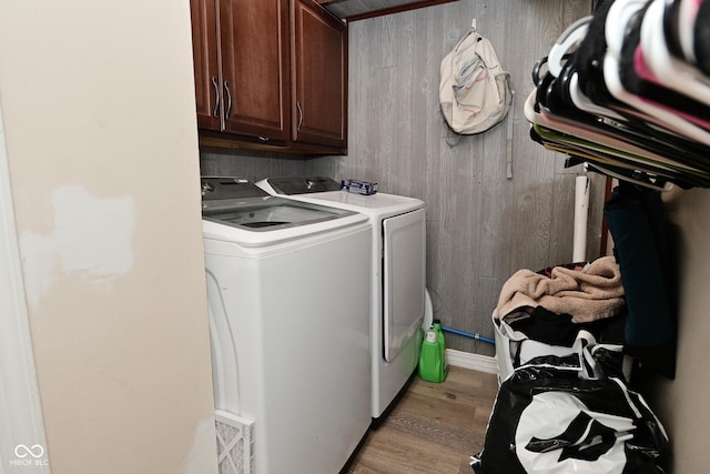 3041 S Kercheval St, Indianapolis, IN 46239 - laundry area featuring light wood finished floors, washer and clothes dryer, wood walls, and cabinet space