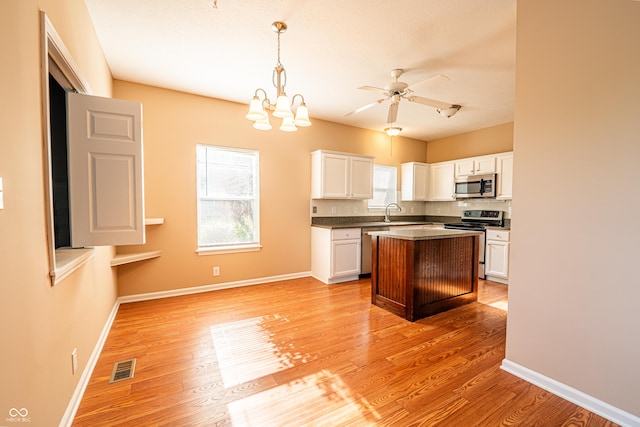 11229 Echo Ridge Ln, Indianapolis, IN 46236 - kitchen featuring appliances with stainless steel finishes, white cabinetry, ceiling fan, light wood finished floors, and dark countertops