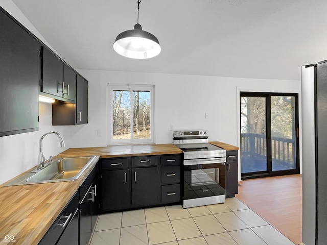 2928 Sheffield Dr, Indianapolis, IN 46229 - kitchen with stainless steel appliances, wooden counters, a sink, dark cabinets, and light tile patterned floors