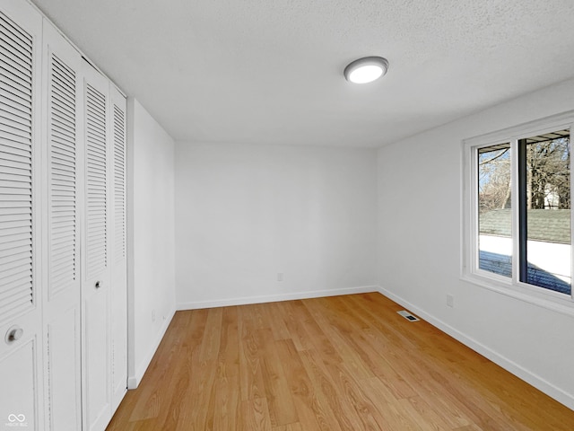 2928 Sheffield Dr, Indianapolis, IN 46229 - unfurnished bedroom featuring light wood-type flooring, baseboards, a closet, and a textured ceiling
