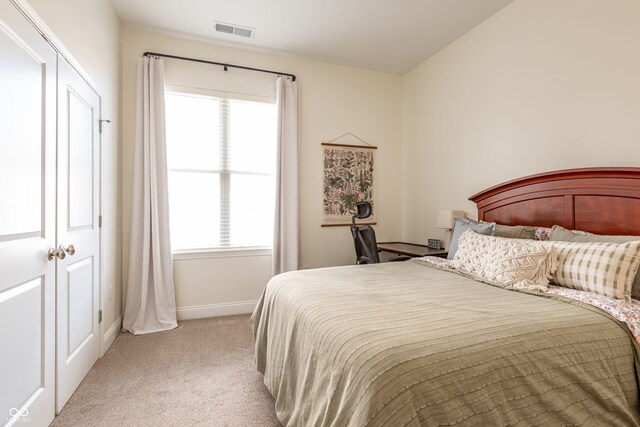 carpeted bedroom featuring baseboards and visible vents