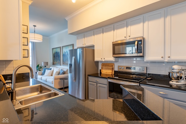 kitchen featuring crown molding, decorative backsplash, hanging light fixtures, a sink, and appliances with stainless steel finishes