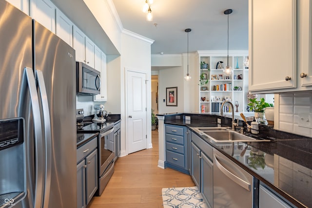 kitchen with open shelves, light wood-type flooring, ornamental molding, a sink, and appliances with stainless steel finishes