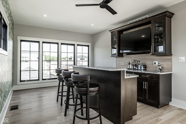 12099 Sigillary Way, Carmel, IN 46032 - indoor wet bar featuring tasteful backsplash, light wood-style flooring, ceiling fan, and recessed lighting